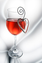 Glass of red wine decorated heart.