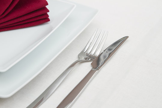 Place Setting With White Plates And Red Folded Napkin