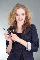 young beautiful woman with make up brushes