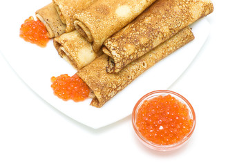 red salmon caviar and crepes on a plate on a white background