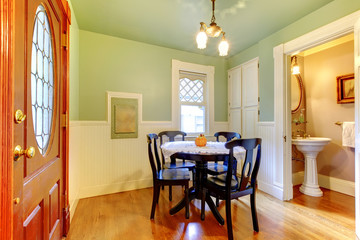 Green antique casual dining room with black table.
