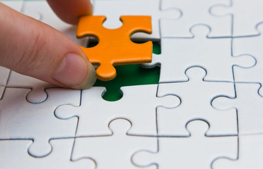 Hands placing piece of a Puzzle