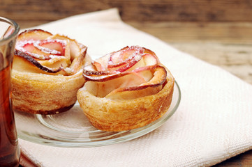 Apple cakes with cup of tea like flower on white napkin