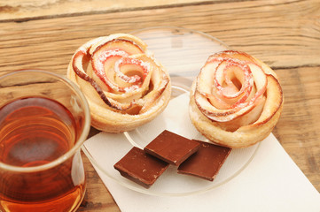 Apple cakes with cup of tea like flower on wooden table