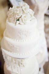White layered wedding cake with roses on top