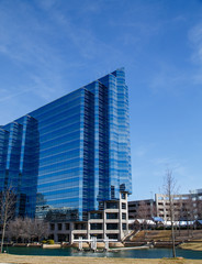 Fototapeta na wymiar Blue Angled Office Tower by Lake
