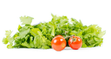 Healthy tomatoes on vine in front of green salad