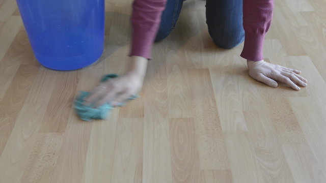 woman cleaning wooden floor with a rag