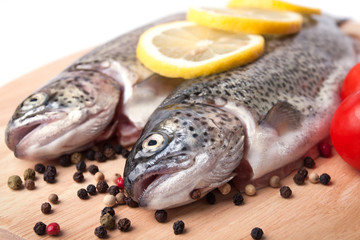 Trout on wooden plate isolated over white