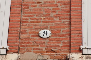Numéro 9 sur façade brique