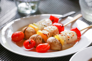 Three colorful barbeque sticks on a white plate
