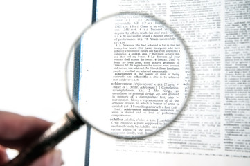 A magnifying glass on the word achievement
