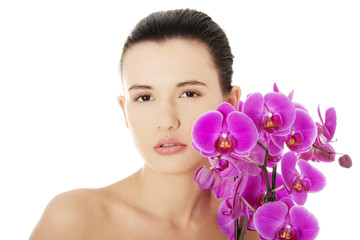 Young woman with health skin and with orchid flower