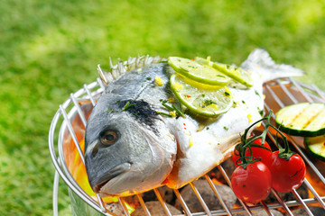 Whole gilthead breem roasting on a fire