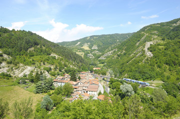 Small Italian village with train on railway bridge