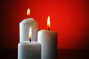 Three candles on red background