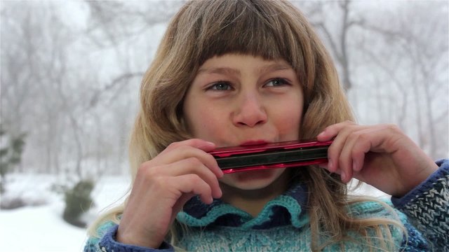 boy playing the harmonica, a boy playing a musical instrument