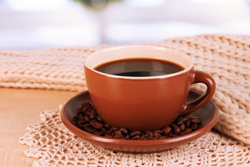 cup of coffee with scarf on table in room