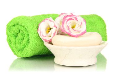 Fototapeta na wymiar Rolled zielone ręczniki, mydła i piękny kwiat samodzielnie