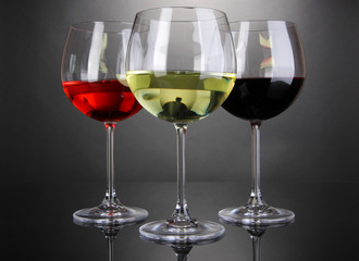 Assortment of wine in glasses on grey background