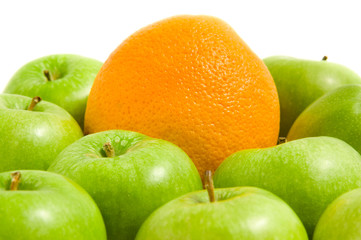 Orange in a pile of green apples