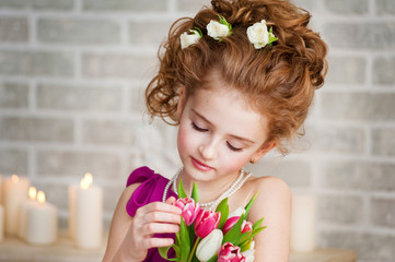 Naklejka premium Portrait of a beautiful girl with tulips