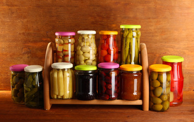 Different conservations on shelves on wooden background