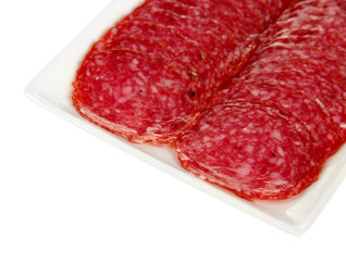 Tasty salami on plate isolated on white