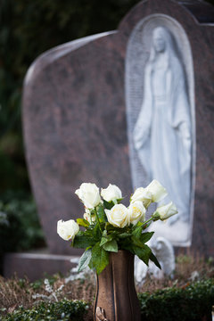 Weiße Rosen auf Grab (Friedhof)