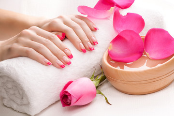 hands with fragrant rose petals and towel. Spa