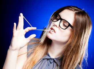 Portrait of strict young woman with nerd glasses and chewing gum
