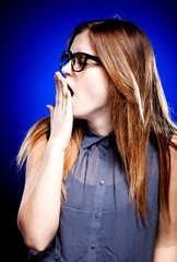 Fototapeta premium Bored young woman with nerd glasses yawning