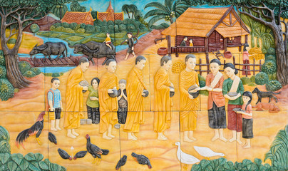Stone carving of offering food to Buddhist monks on temple wall