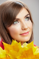 Fototapeta premium Yellow autumn leaves, close up woman face