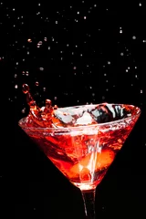 Foto op Canvas rode spetterende cocktail op zwart © nikkytok