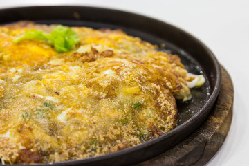 Fried oysters with egg and flour on hot plate