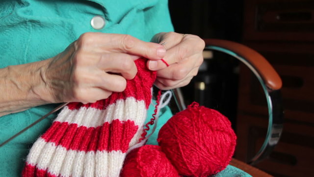 closeup of old womans hands knitting