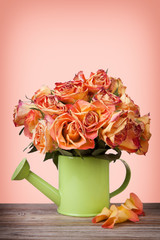 A bouquet of vintage roses in green watering can