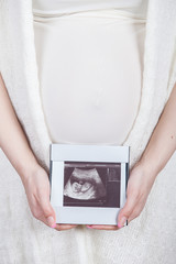 young pregnant woman looking at ultrasound image