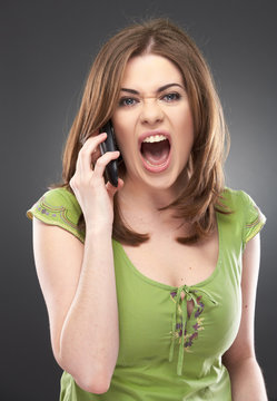 angry woman shouts in phone isolated on gray
