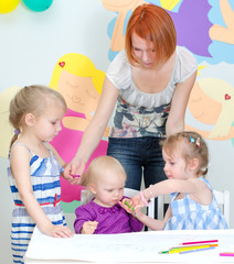 Children drawing with pencils in classroom