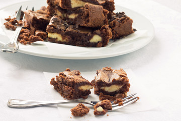 Pieces of cheesecake brownies on a baking paper
