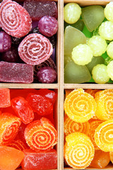 Multicolor candies in wooden box, close up