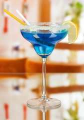 Blue cocktail in glass on room background
