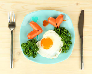 Sausages in form of hearts, scrambled eggs and parsley,