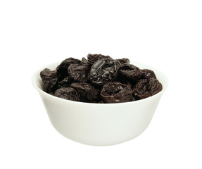 Dried plums or prunes  in a bowl isolated on white
