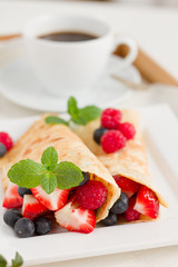 Eierkuchen mit Beeren und Tasse Kaffee