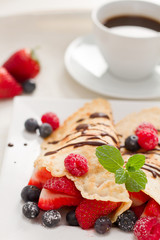 Eierkuchen mit Beeren und Tasse Kaffee