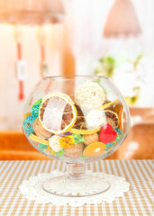 Dried oranges, wicker balls and other home decorations in glass