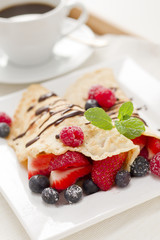 Eierkuchen mit Beeren und Tasse Kaffee